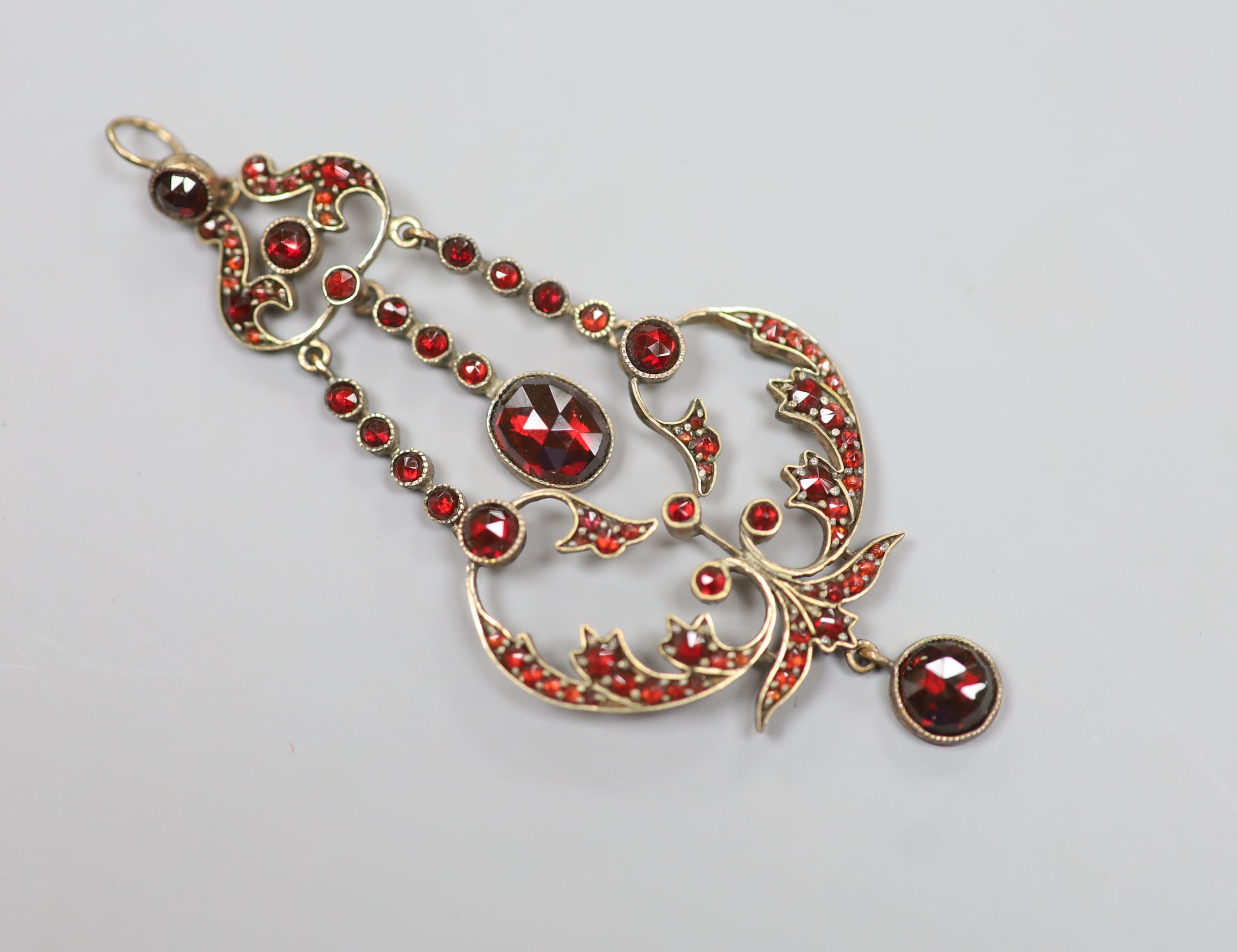 A late Victorian gold plated and facet garnet garnet cluster set drop pendant, overall 75cm, 6.9 grams.